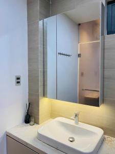 Cồn Giả ViênにあるMica's Houseの白い洗面台と鏡のあるバスルーム