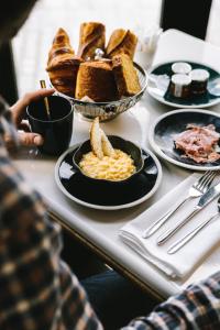 a table with plates of breakfast foods on it at Hôtel Maison Chiberta in Anglet