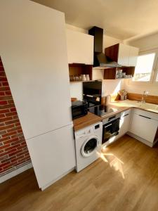 a kitchen with a white stove and a washer at Appartement 3 Chambres & Dernier étage in Amiens +14 photos