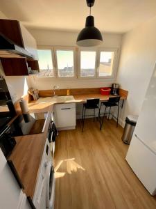 a kitchen with a sink and a table with chairs at Appartement 3 Chambres & Dernier étage in Amiens