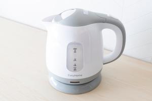 a white electric kettle sitting on a table at The Nest Koenji Cozy Stay near Station Easy Access to Shinjuku in Tokyo