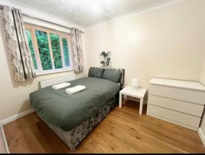 ein Schlafzimmer mit einem grünen Bett und einem Fenster in der Unterkunft 1 Berkeley Court in Hackbridge