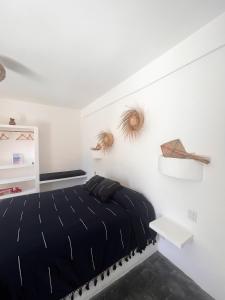 a bedroom with a black bed and white walls at Casa Leone La Punta in Brisas de Zicatela