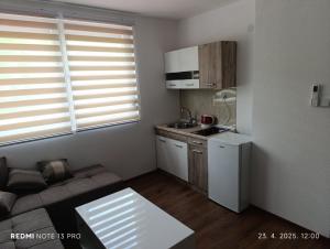 a small living room with a couch and a kitchen at Apartmani 3M in Foča