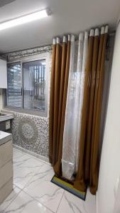 Studio moderne LCE في دوالا: مطبخ بستائر بنية اللون ونافذة