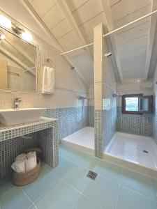 a bathroom with a shower and a sink and a tub at Restia House in Steni Vala Alonissos