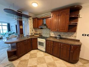 a kitchen with wooden cabinets and a stove top oven at Gleem Sea View 4 in Alexandria +11 photos