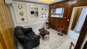 a living room with a leather couch and a table at Studio moderne LCE in Douala