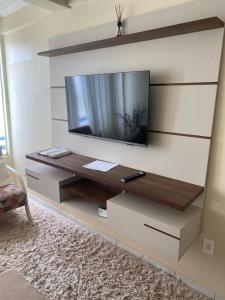 a living room with a flat screen tv on a wall at Apartamento in Cabedelo