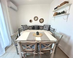 a dining room with a white table and chairs at Restia House in Steni Vala Alonissos +29 photos