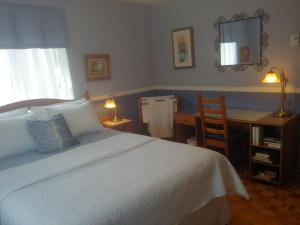 a bedroom with a white bed with a desk and a chair at 3 Bedrooms 3 beds near metro -2 Parking Free in Montréal