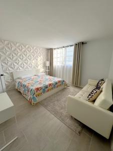 Un dormitorio blanco con una cama y un sofá. en Beachfront one bedroom in the Tides in Hollywood, en Hollywood