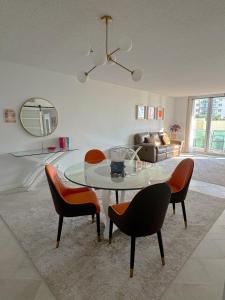 Una sala de estar con una mesa de cristal y sillas. en Beachfront one bedroom in the Tides in Hollywood, en Hollywood