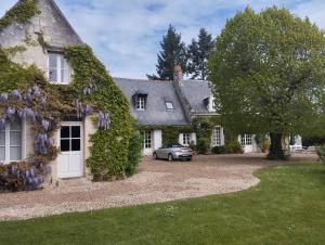 a house with a car parked in front of it at La Coquerie in Fondettes