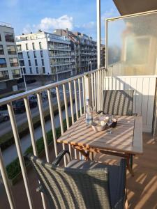 a table and chairs on a balcony with a view of a city at Gezellige studio met balkon - Santhooft centrum Nieuwpoort-bad in Nieuwpoort