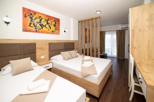 una camera d'albergo con due letti e un dipinto sul muro di GAVIA Apartments - Ulcinj a Ulcinj