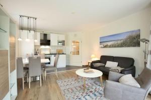 a living room with a couch and a table at Wohnung Aurora im Haus Nautilus in Wangerooge
