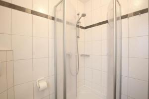 a shower with a glass door in a bathroom at Wohnung Aurora im Haus Nautilus in Wangerooge +10 photos
