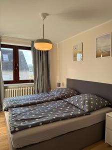 a bed with a blue comforter in a bedroom at Ostseeliebe 5 in Dahme