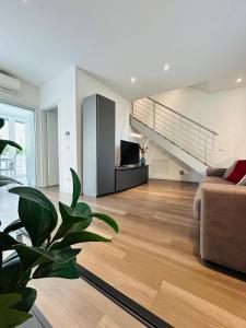a living room with a couch and a staircase at Menotti Attico-Flexrent Immobiliare Abissinia in Riccione