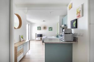 a kitchen with a counter and a room with a bed at Studio 30 m2 tout confort - RER à 3 min, accès Paris & Disneyland in Villiers-sur-Marne