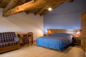 a bedroom with a bed and a chair and a table at Malga Mariech in Valdobbiadene