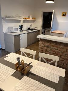 a kitchen with a table and chairs and a counter at Apartman - Garden - Vendégház in Nesvady