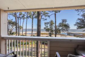 a balcony with a view of the beach and trees at Oceanfront Sunrises on Mitchelville Beach in Hilton Head Island