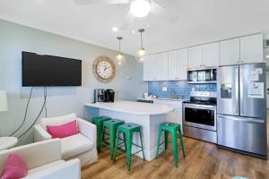 a kitchen with a white counter and green stools at Oceanfront Sunrises on Mitchelville Beach in Hilton Head Island