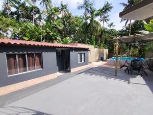 a house with a patio and a swimming pool at Suítes em Cananéia SP in Cananéia