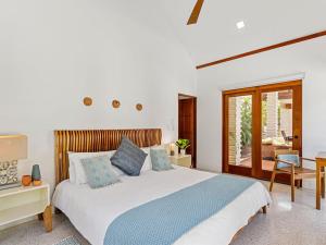 una camera da letto con un letto, un tavolo e una sedia di Blue Iguana, steps from the beach Playa Langosta a Tamarindo