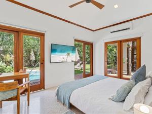 una camera da letto con un letto, una scrivania e finestre di Blue Iguana, steps from the beach Playa Langosta a Tamarindo Altre 29 foto