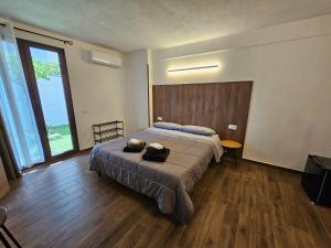 une chambre avec un lit et une grande fenêtre dans l'établissement TERA Cagliari, à Cagliari