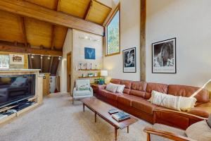 トラッキーにあるNorthstar Condo with Forested Viewsのリビングルーム(ブラウンレザーのソファ、テレビ付)