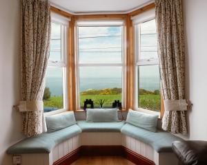 a window seat with a view of the ocean at 3 bedroom - Sea View - Pet Friendly in Pistyll