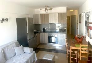 a living room with a white couch and a kitchen at Mirador Paraiso in Adeje