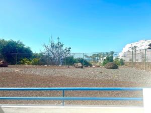 a metal fence in front of a dirt field at Mirador Paraiso in Adeje