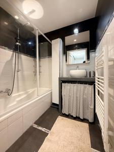 een badkamer met een bad, een wastafel en een douche bij Apt with 2 bedrooms, terrace, pool & parking in Antibes