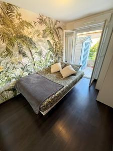 een slaapkamer met een bed met tropisch behang bij Apt with 2 bedrooms, terrace, pool & parking in Antibes +6 foto's