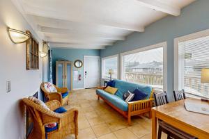 a living room with a blue couch and chairs at Periwinkle in Pacific Beach