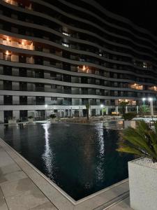 ein großes Gebäude mit Schwimmbad bei Nacht in der Unterkunft ZIGON Summer Place by Casa Del Mar in Mamaia
