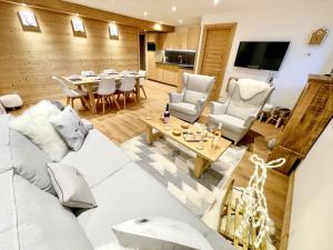 a living room with a couch and a table at Le Janus - Les Tanières - pied des pistes, garage, terrasse avec sauna in Montgenèvre