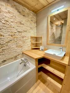 a bathroom with a sink and a bath tub and a mirror at Le Janus - Les Tanières - pied des pistes, garage, terrasse avec sauna in Montgenèvre +28 photos