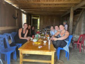 a group of women sitting around a wooden table at Mama Gia Homestay in Sa Pa