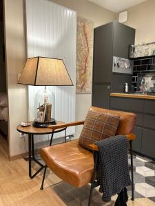 a table with a lamp and a chair in a kitchen at Chez Marlène in Comblanchien +5 photos