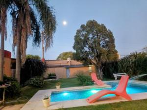a swimming pool with two chairs in a yard at COMPLEJO DE VARIOS LOFT EN RAFAELA A 100 METROS de la RUTA 34 in Rafaela