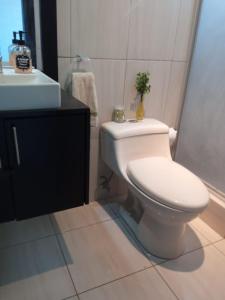 a bathroom with a toilet and a sink at Moderno Apartamento completo 3piscinas 2jacuzzi y Playa cerca in Tonsupa +10 photos