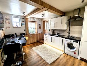 a kitchen with a washer and dryer in it at Ramsgate Seafront Apartment with Jacuzzi Bath & Pool Table in Ramsgate