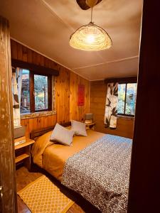 ラ・エンセナダにあるCabañas y Camping Barloventoのベッドとシャンデリアのある寝室