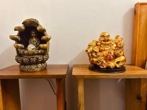 a gold statue sitting on top of two wooden tables at Jetsunma Homestay in Darjeeling